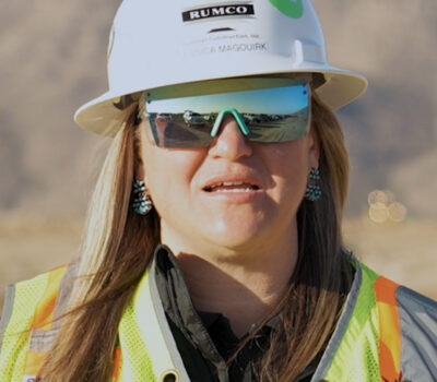 Employee-owner Jessica Magourik wearing a white hard hat, reflective sunglasses, and a high visibility vest.