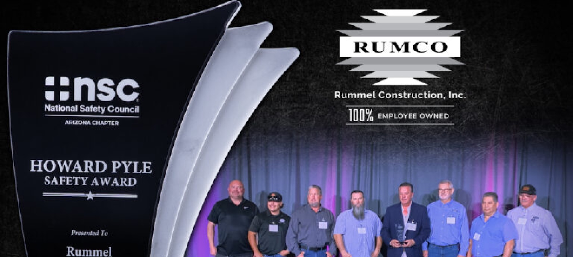 A group of men stand on stage to accept the Howard Pyle Safety Award.
